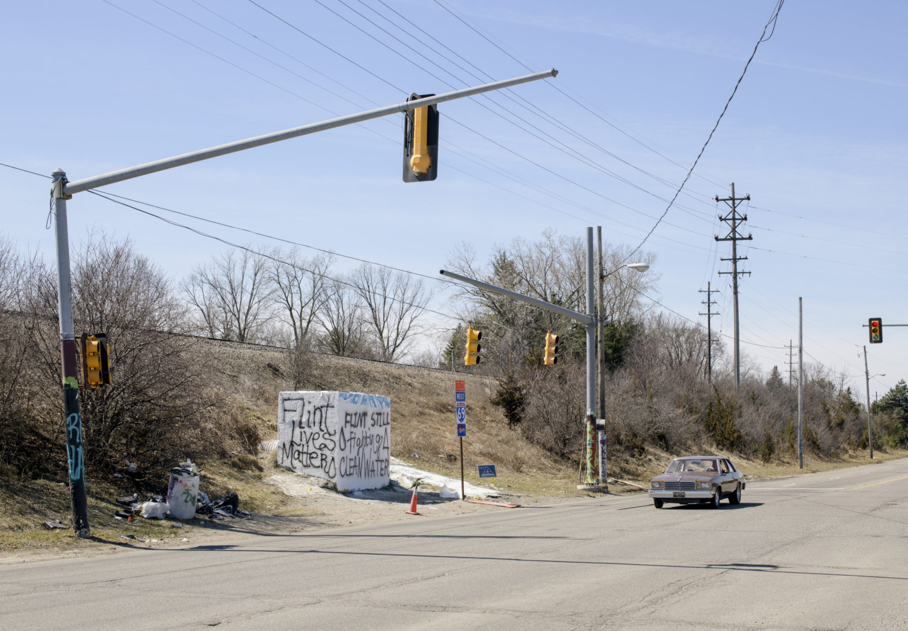 Road intersection with roadside signs displaying 'Flint Lives Matter'