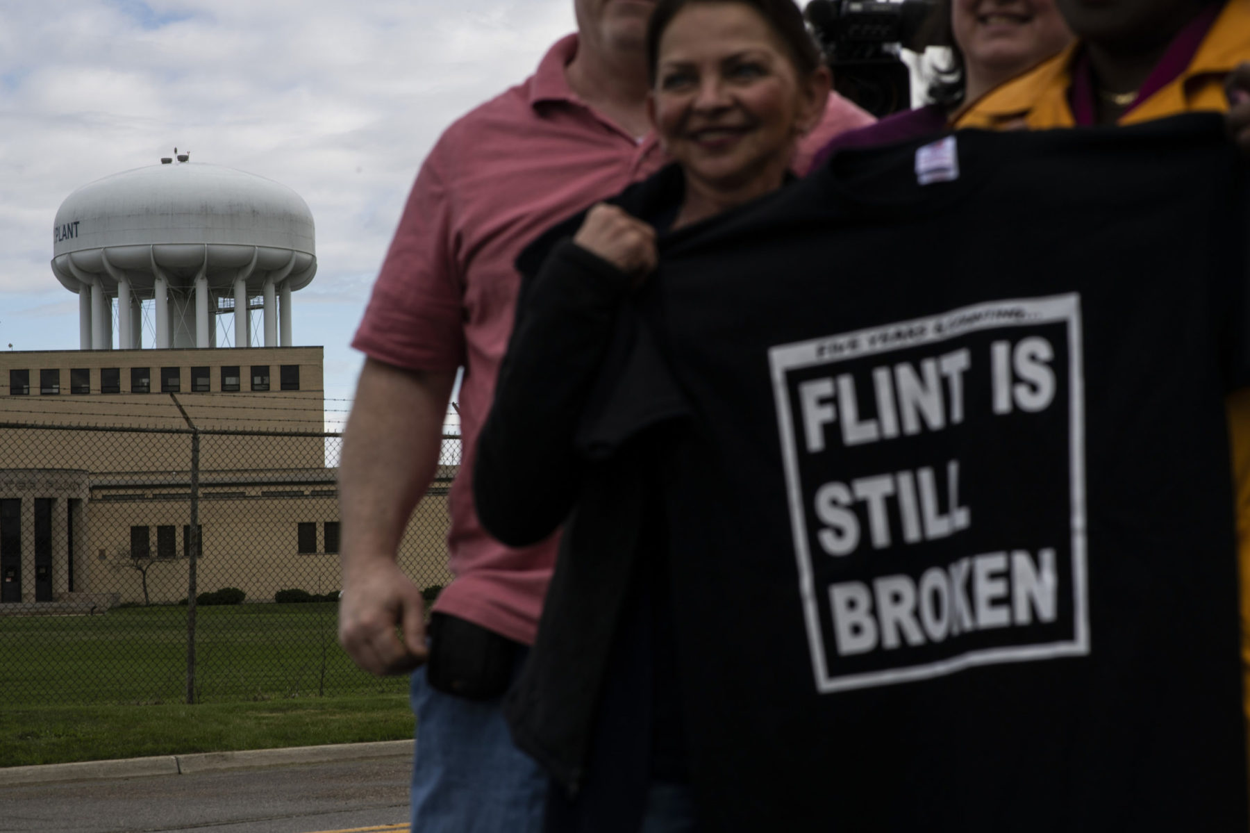 Closeup of person holding shirt saying 'Flint is still broken'