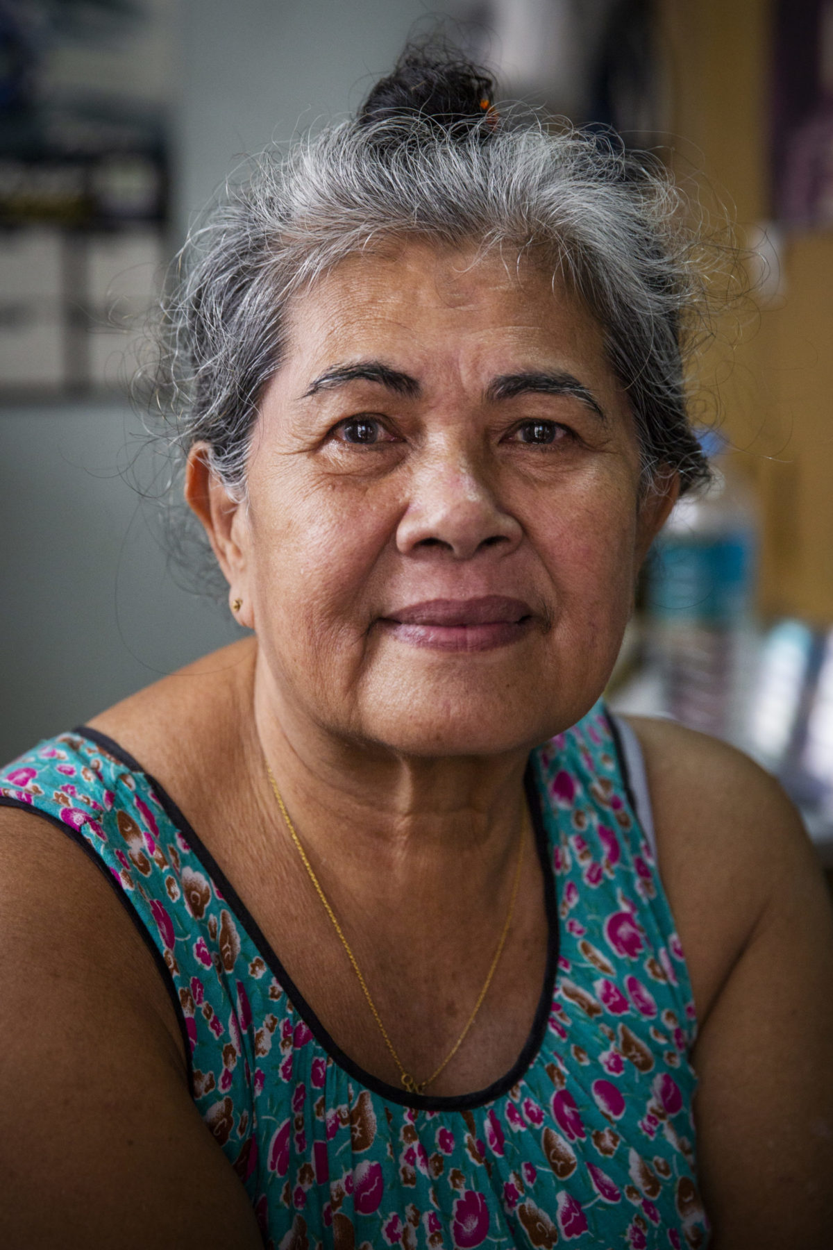 A person with graying hair wearing denim smiles. 