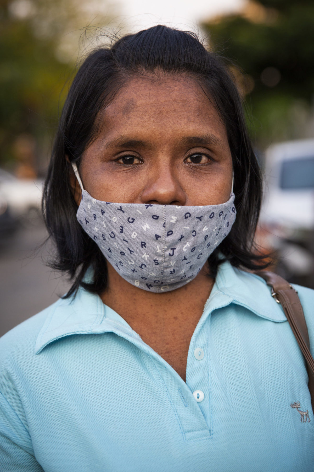 A young person wears a mask over their mouth. 