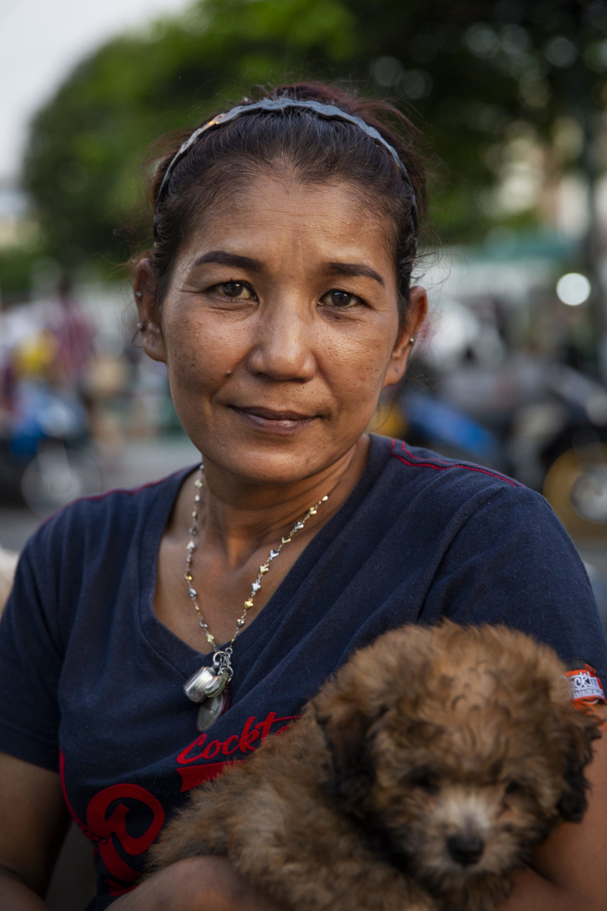 A person holds her brown puppy. 