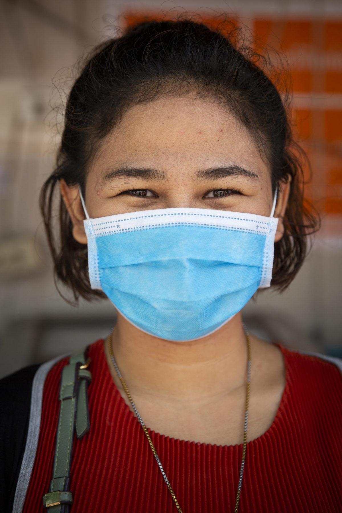 A young person smiles behind their mask.