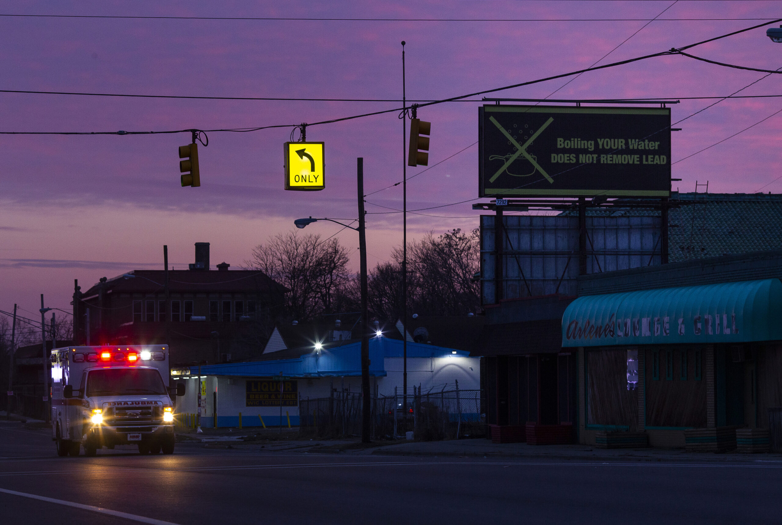 Street intersection with incoming ambulance, purple sky in the background