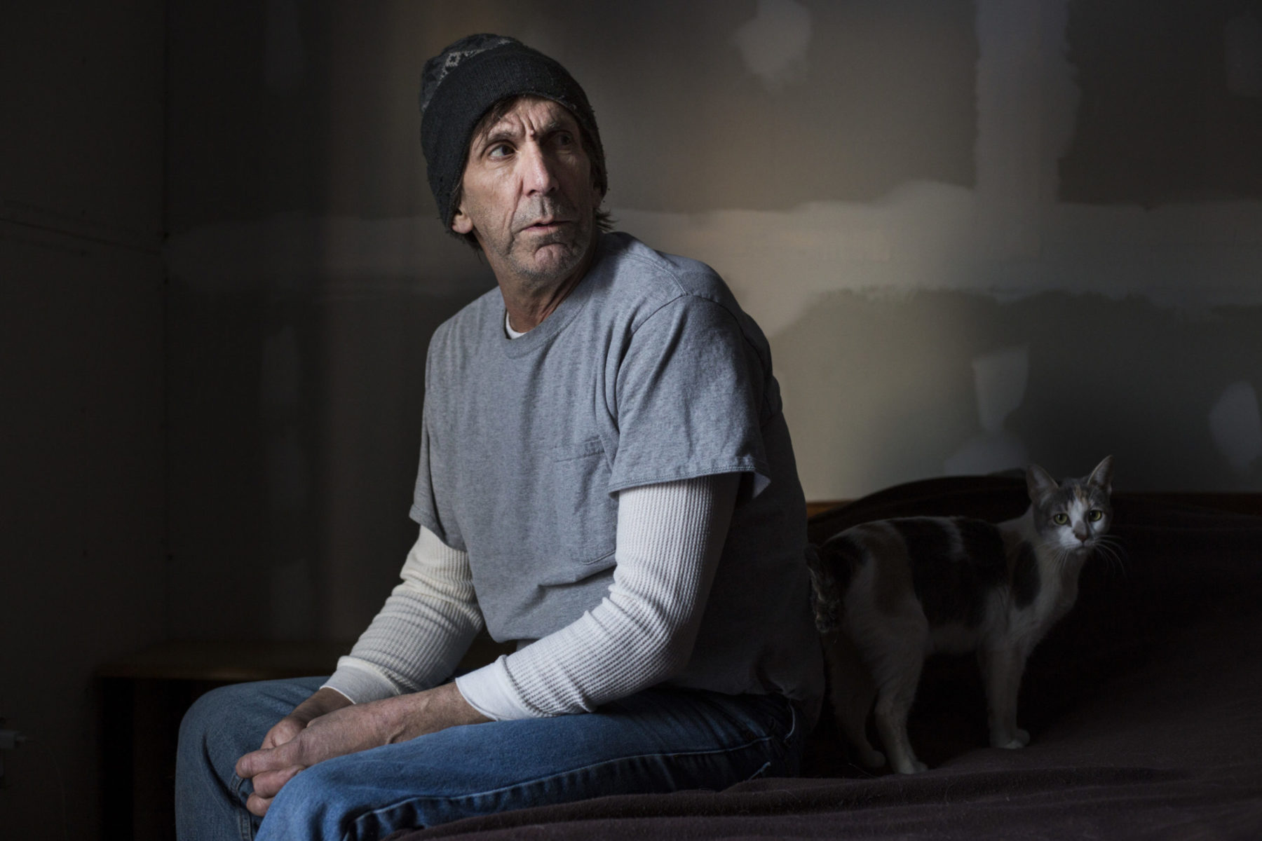 Tim Monahan, 58, sits in his bedroom at his home