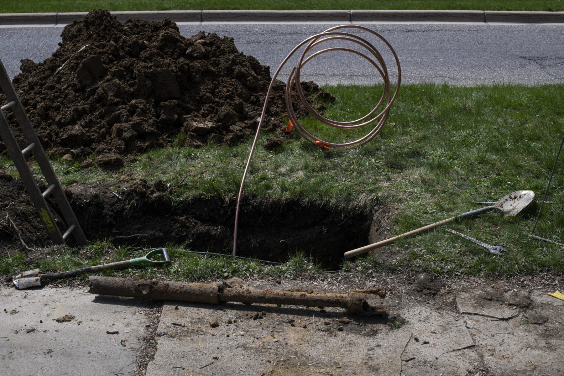Wiring emerging from hole dug into the ground