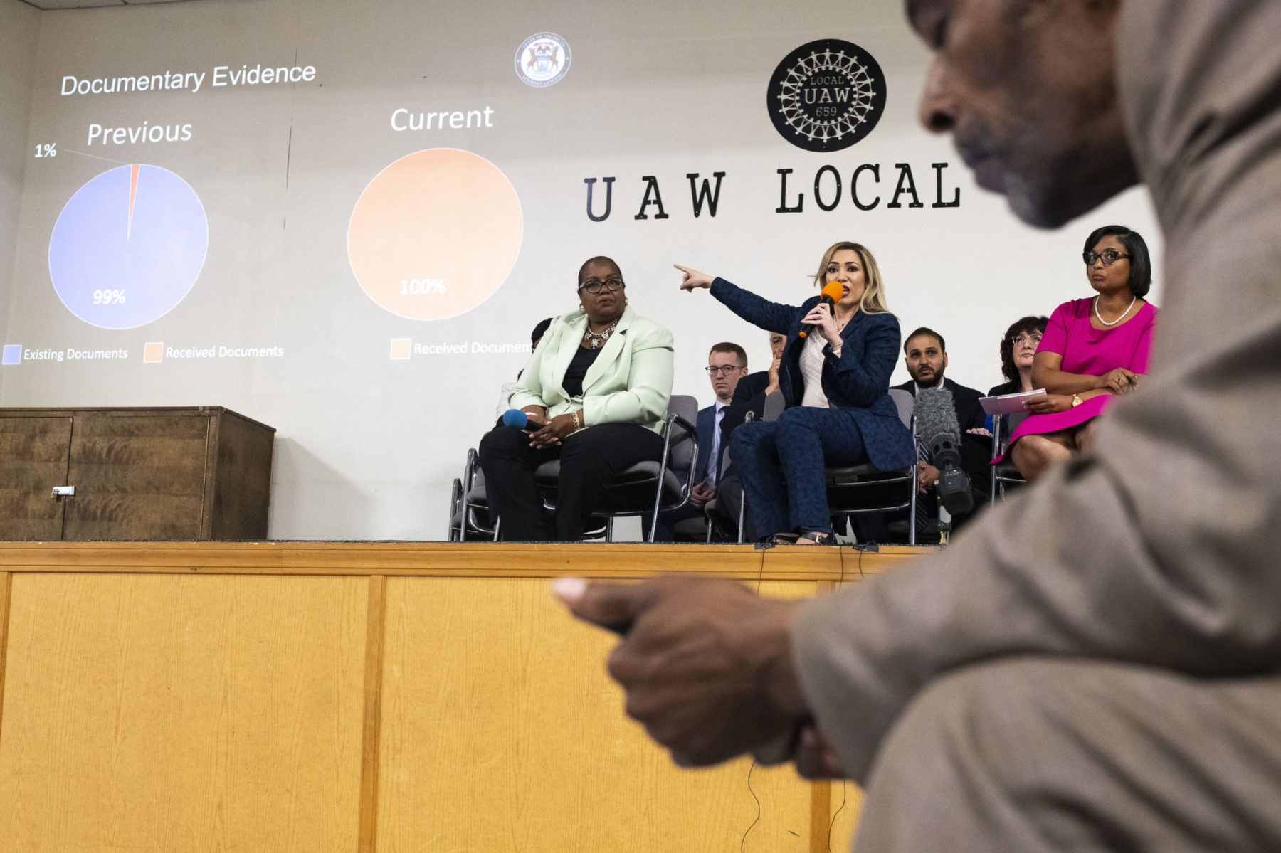 Background of ground of panelists, foreground of person