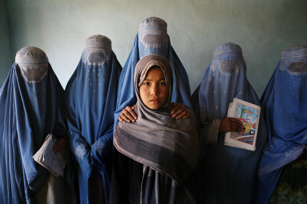 Person standing in the center surrounded by a group, all looking towards the camera.