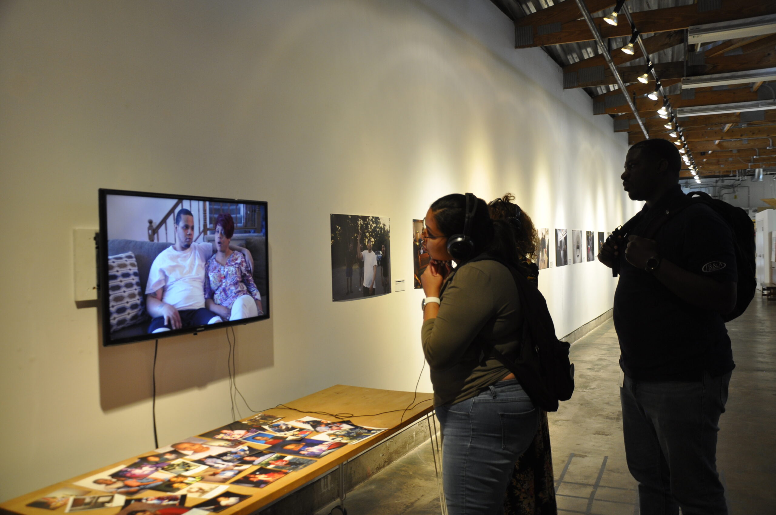 A woman wearing headphones watches a video of DaShawn Horne during his recovery.