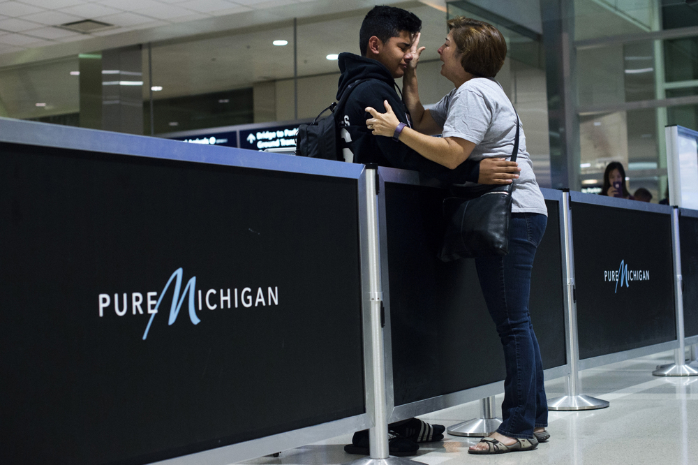 From left, Bryan Quintana-Salazar, 13, cries as his former teacher, Jennifer Walsh, of Ann Arbor, wipes tears from his face before he enters the security line with his family to travel to Mexico on Tuesday, August 1, 2017 at the Detroit Metropolitan Airport in Romulus, Michigan, USA. Lourdes Salazar Bautista (not pictured), took her children with her to Mexico as she was deported. Now, to stay with their mother, Quintana-Salazar and his older sister attend a school in Toluca, Mexico. Photo by Rachel Woolf.