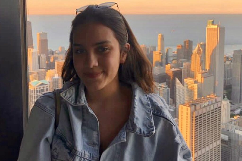Sofia wears a denim jacket with the Chicago skyline and Lake Michigan in the background