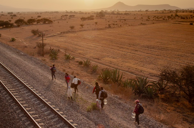 A family from Venezuela are seen walking along the train tracks searching for the best point of access to board a freight train, popularly known as “La Bestia” towards the northern border of Mexico and the U.S. Photo by Oscar B. Castillo and Wil Sands.